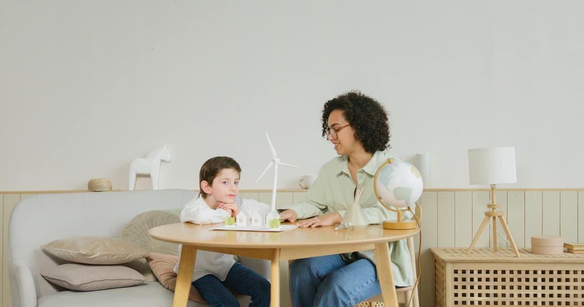 Woman and boy examine a globe and windmill model together, representing parent-child engagement in learning.